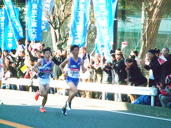 東工大応援団の前を駆け抜ける松井さん（左）