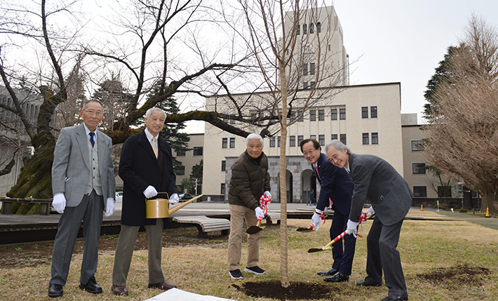 鍬入れを行う益学長（右から2人目）、佐藤理事・副学長（右から1人目）、近隣自治会の皆様