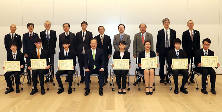 授与式後の記念撮影（前列左から、吉田さん、タンピパットさん、伊藤さん、益学長、松永さん、ディンさん、奥山さん、石沢さん）