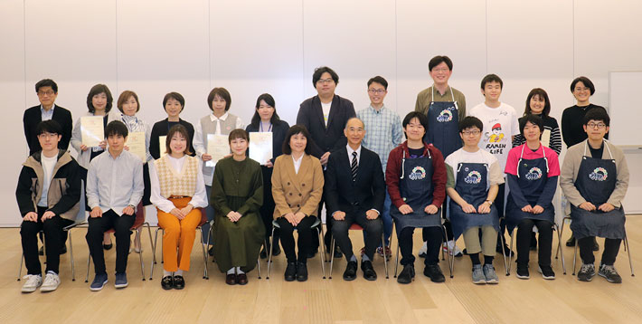認定証授与式に参加した学生および教職員と、道又紀子学生相談部門長（前列左から5人目）、岡村副学長（同6人目）