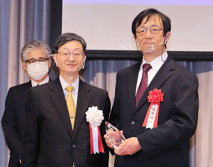 授賞式での高田教授（右）と山川鉃郎日本ITU協会理事長（左）
