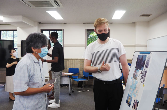 山元教授にポスターの内容を説明する留学生