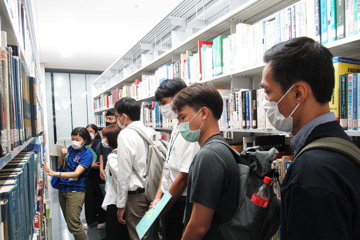キャンパスツアーで附属図書館を見学するTAIST学生