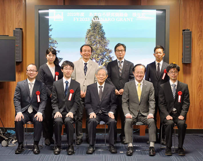 授与式に参加した採択者（前列左から、家永助教、平田助教、浅野名誉教授、益学長、山口助教。後列左から、永嶌助教、渡辺理事・副学長（研究担当）、新田研究戦略部門長、盛田助教）