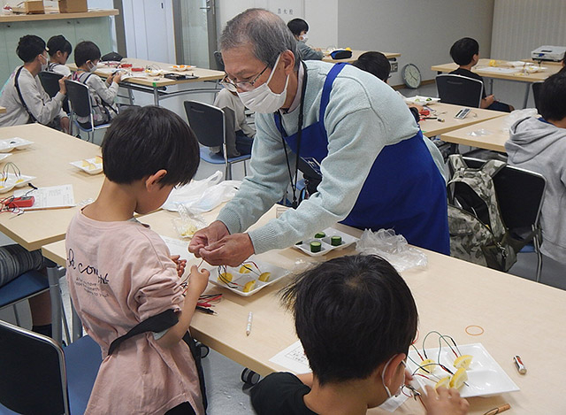 くらりか講師にレモン電池の作り方を教わる子供たち