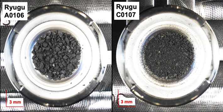図1. 小惑星リュウグウ（162173）から採取された2つのチャンバーの初期サンプルの写真（左が第1タッチダウンで採取したAチャンバーサンプルのうち、サンプルID：A0106、右がリュウグウの地下物質を含む第2タッチダウンで採取したBチャンバーのうち、サンプルID：C0107）。このうち、A0106（13.08 mg）とC0107（10.73 mg）というサンプルIDを本研究の多段階抽出に用い、精密な化学分析を行った。写真は、サンプル配布前にJAXAキュレーション施設のクリーンチャンバーで撮影。