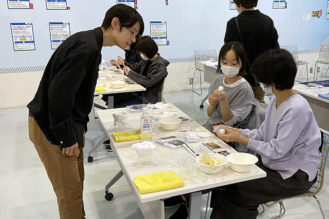 参加者に実験のアドバイスをする学生スタッフ