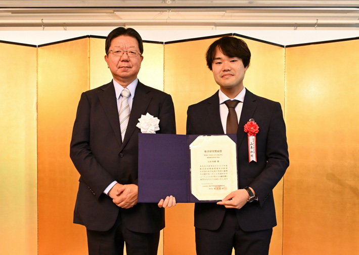 （左から）船井情報科学振興財団の船井哲雄理事長、褒賞式で賞状を授与された山本助教