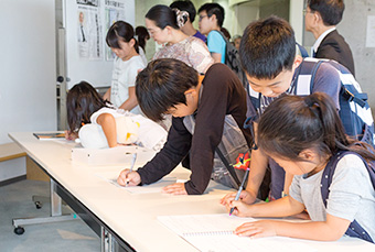 大隅栄誉教授にメッセージを書く来場者