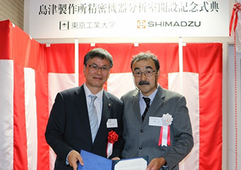 協定に署名した丸山秀三島津製作所常務執行役員（左）と安藤真理事・副学長（右）