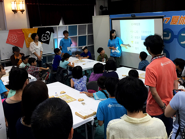 腸内細菌の役割について解説する学生スタッフ