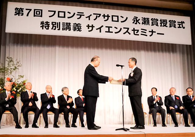 宮田フロンティアサロン財団代表理事（左）から賞状を受け取る笹川准教授（右）
