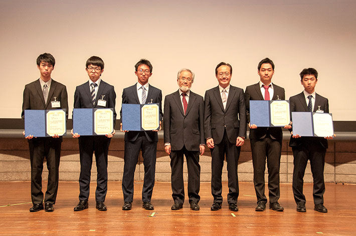 大隅栄誉教授（左から4人目）、益学長（同5人目）と一緒に記念撮影に臨んだ奨学生