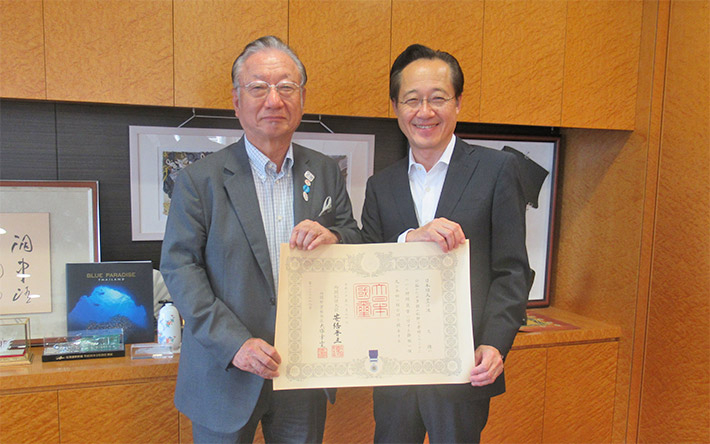 褒章の記を手にする滝氏(左)と益学長