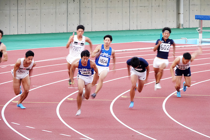 4×100m男子リレー_第3走者の妻木さんから第4走者の永島さんにバトンタッチ（右から3レーン目が東工大）