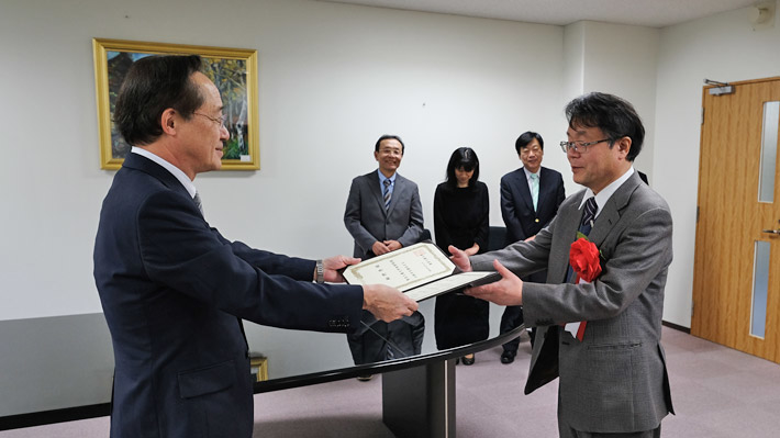 益学長(左)から細野特命教授(右)へ称号記を授与