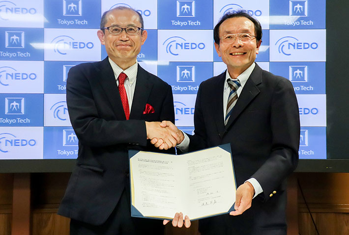 覚書署名式でのNEDO 渡邉政嘉理事（左）と渡辺治理事・副学長（研究担当）（右）