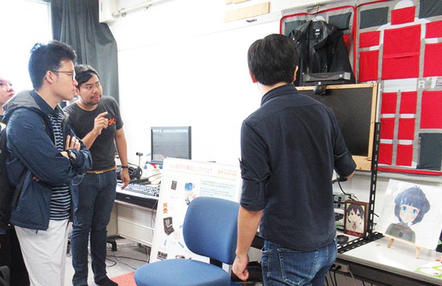 科学技術創成研究院 長谷川研究室にて説明を行うTAIST学生（左奥）