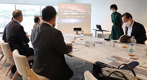 伊藤准教授（中央）から未来の人類研究センターの活動内容について説明を受ける竹本大臣（左・手前）
