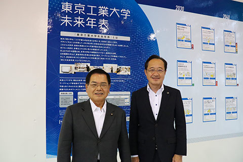 東京工業大学未来年表の前で記念撮影する益学長（右）と竹本大臣（左）