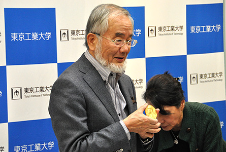 ノーベル賞のメダルを手に説明する大隅栄誉教授