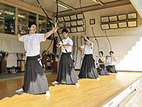 日々の練習で順番に的に向かって弓を引く弓道部員