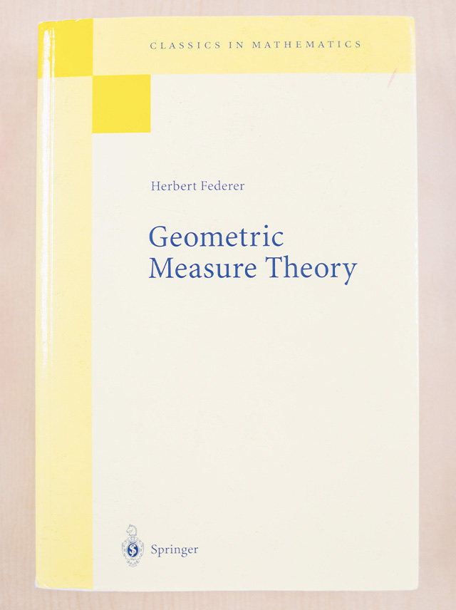 幾何学的測度論の基礎を築いたフェデラーによる1969年出版の著書『Geometric Measure Theory』。700ページほどの大著で、この研究分野のマイルストーンであり、その後の研究に大きな影響を与え続けている。