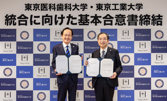 統合に向けた基本合意書の締結式にて、東京医科歯科大学の田中雄二郎学長（右）と
