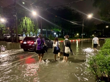 浸水した大学を裸足で歩く学生